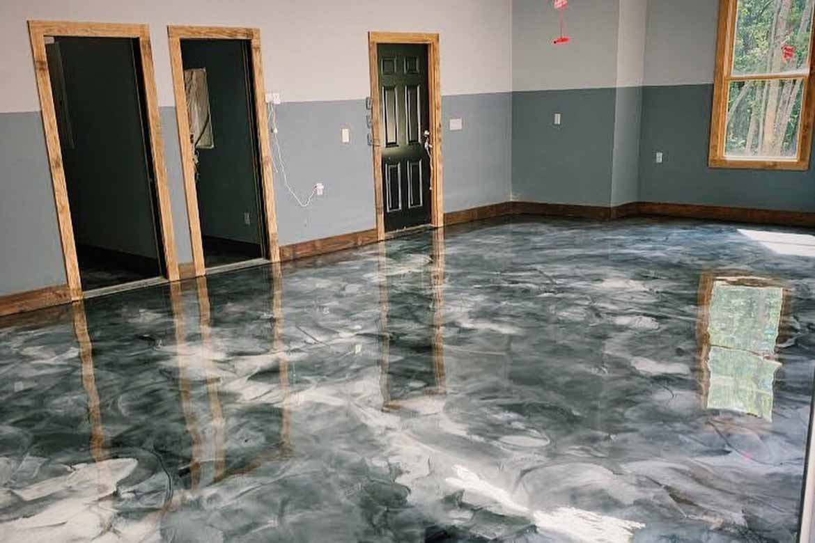 a room with epoxy flooring black and white patterned floor and a reflective mirror.